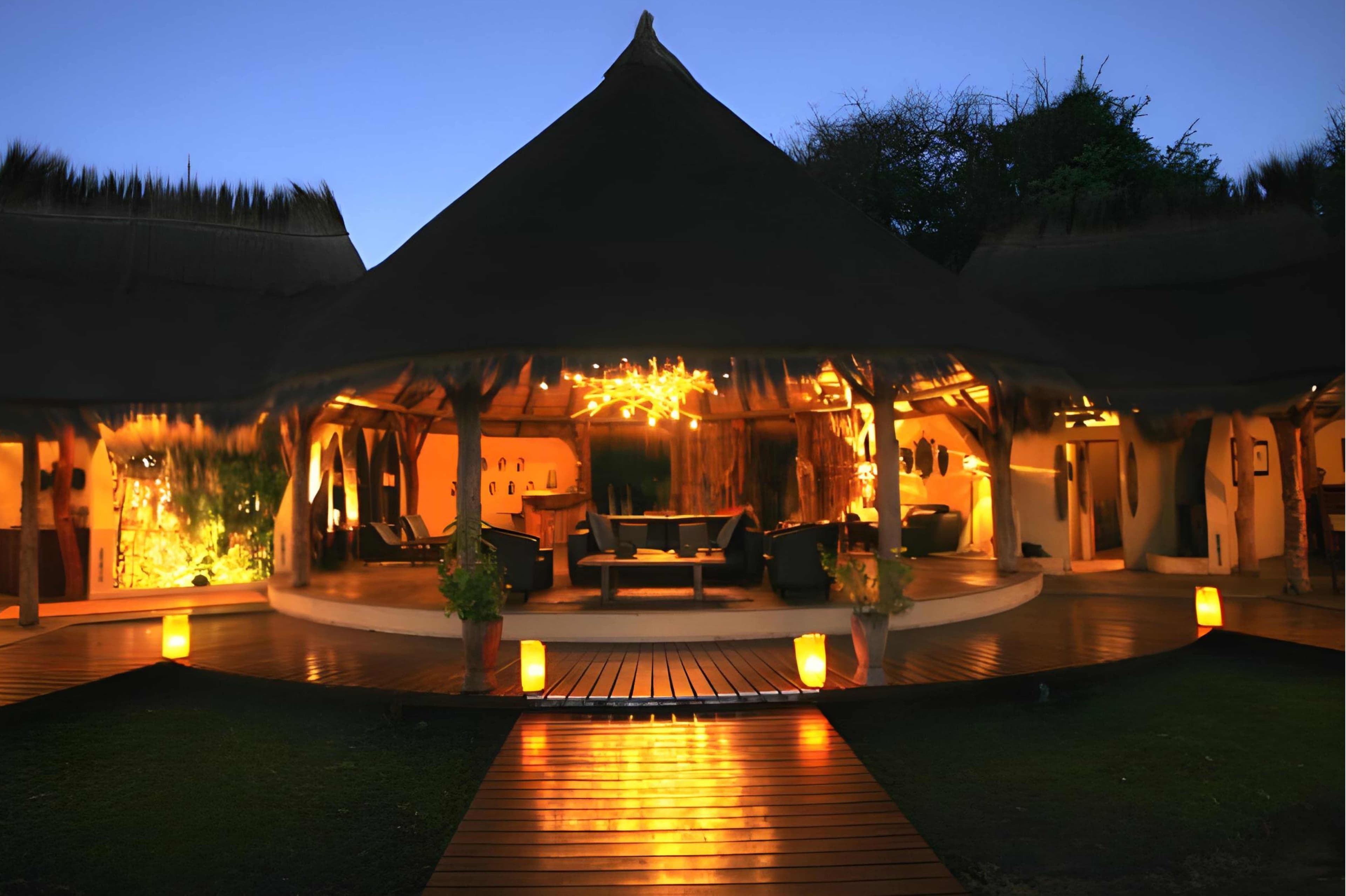 Camp Kwando Lodge at dusk with candlelit walkway